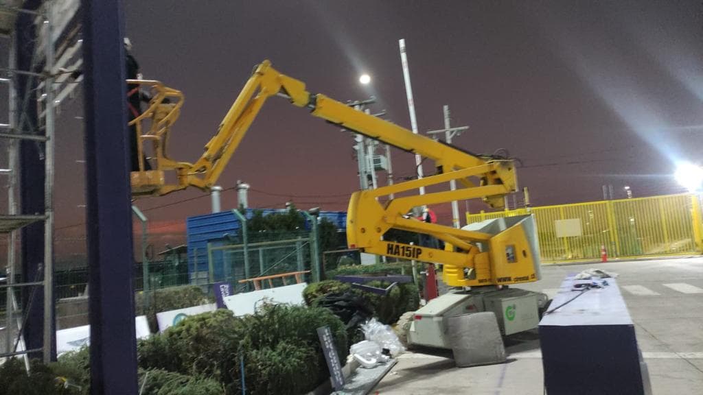 Plataforma de brazo articulado Haulotte HA151P trabajando de noche en instalación industrial